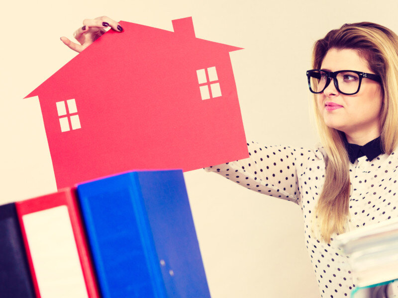 Thining business woman in office holding house Thining business woman in office holding house