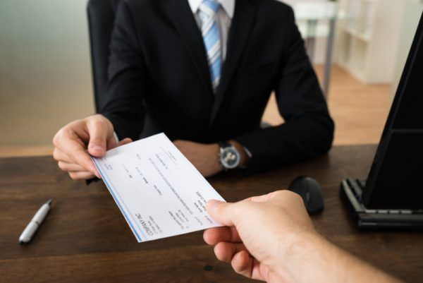 AdobeStock_90091685-800×534-600×401 Person passing check to another person