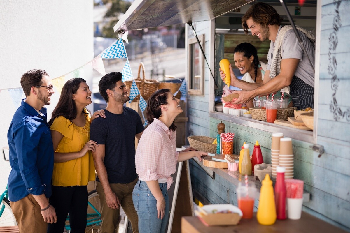 Smiling waiter giving order to customers at counter Smiling waiter giving order to customers at counter