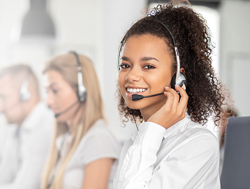 Call center worker accompanied by her team. Woman on headset