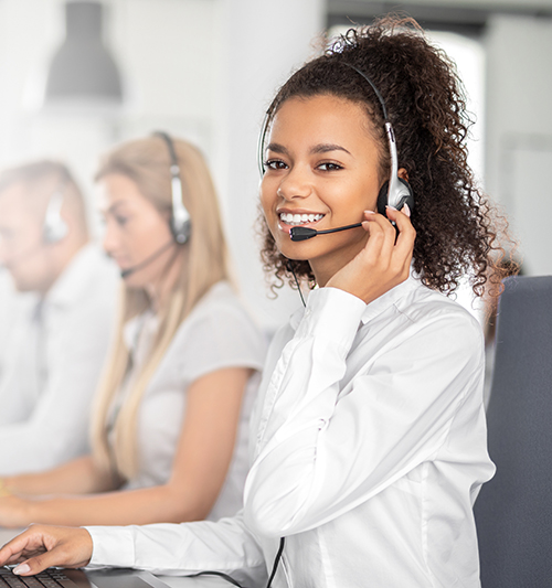 Call center worker accompanied by her team. Women on Headset
